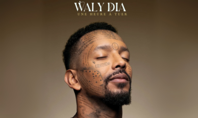 Portrait de Waly Dia les yeux fermés, avec des mots tatoués sur le visage, illustrant l’affiche de son spectacle "Une heure à tuer".