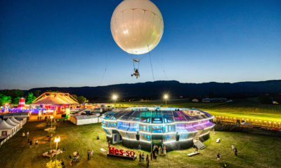 Un artiste suspendu sous le ballon Moon Music au-dessus du public du Paléo Festival.