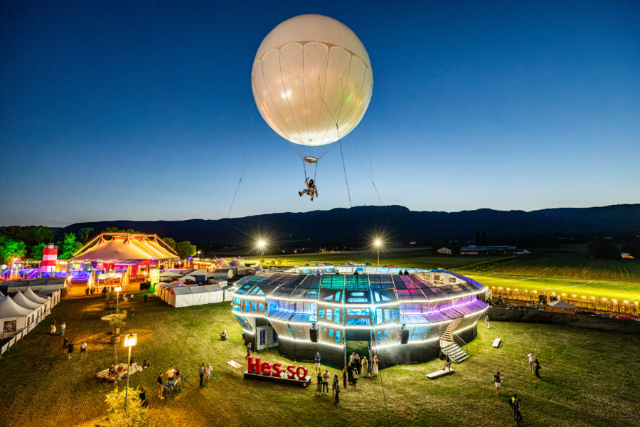 Un artiste suspendu sous le ballon Moon Music au-dessus du public du Paléo Festival.